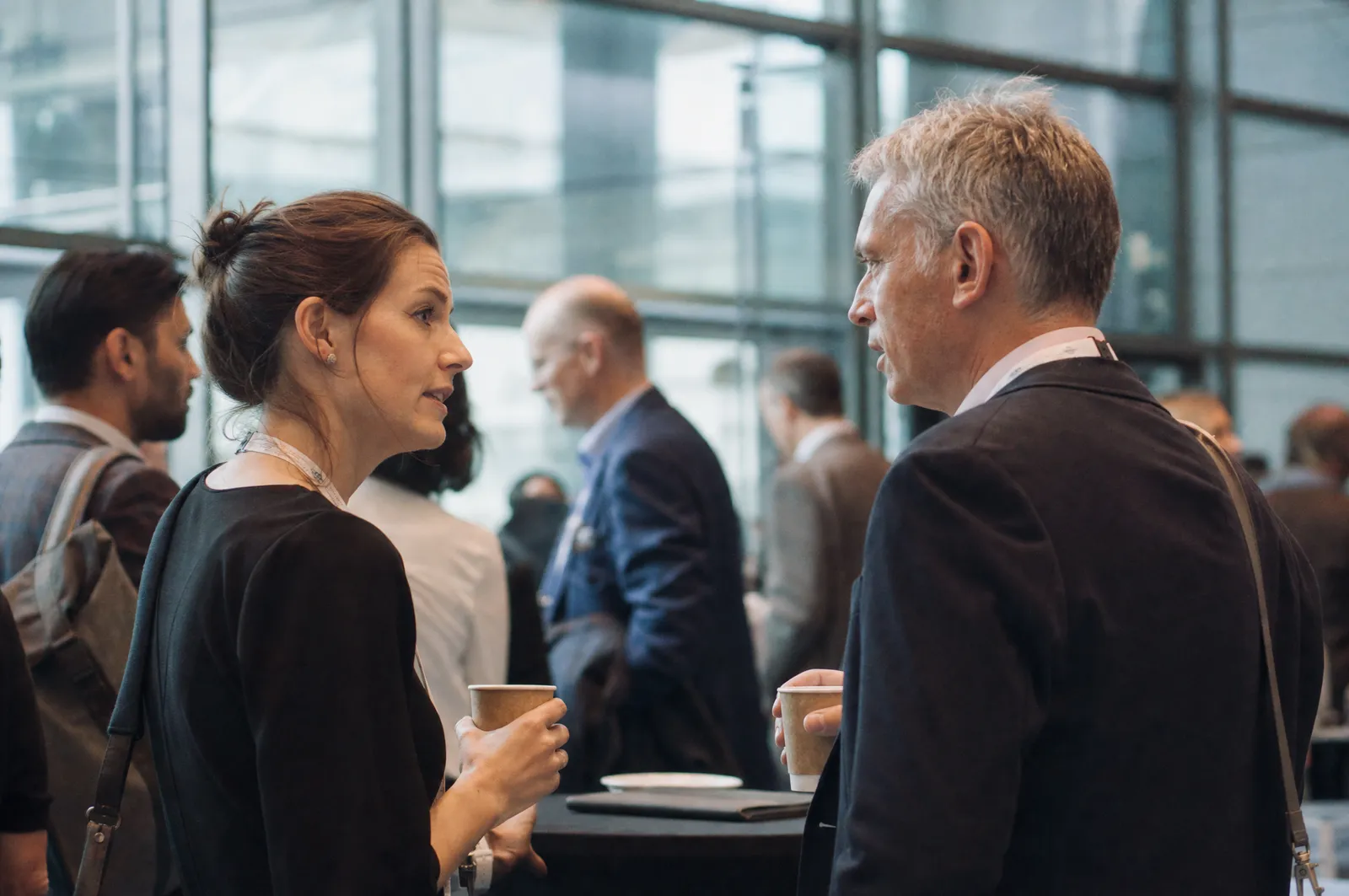 Two delegates talking over coffee during a conference break